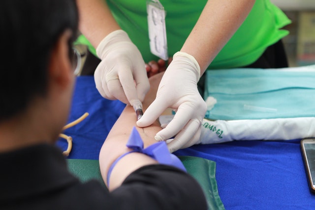 Nurse draws blood from patient's arm